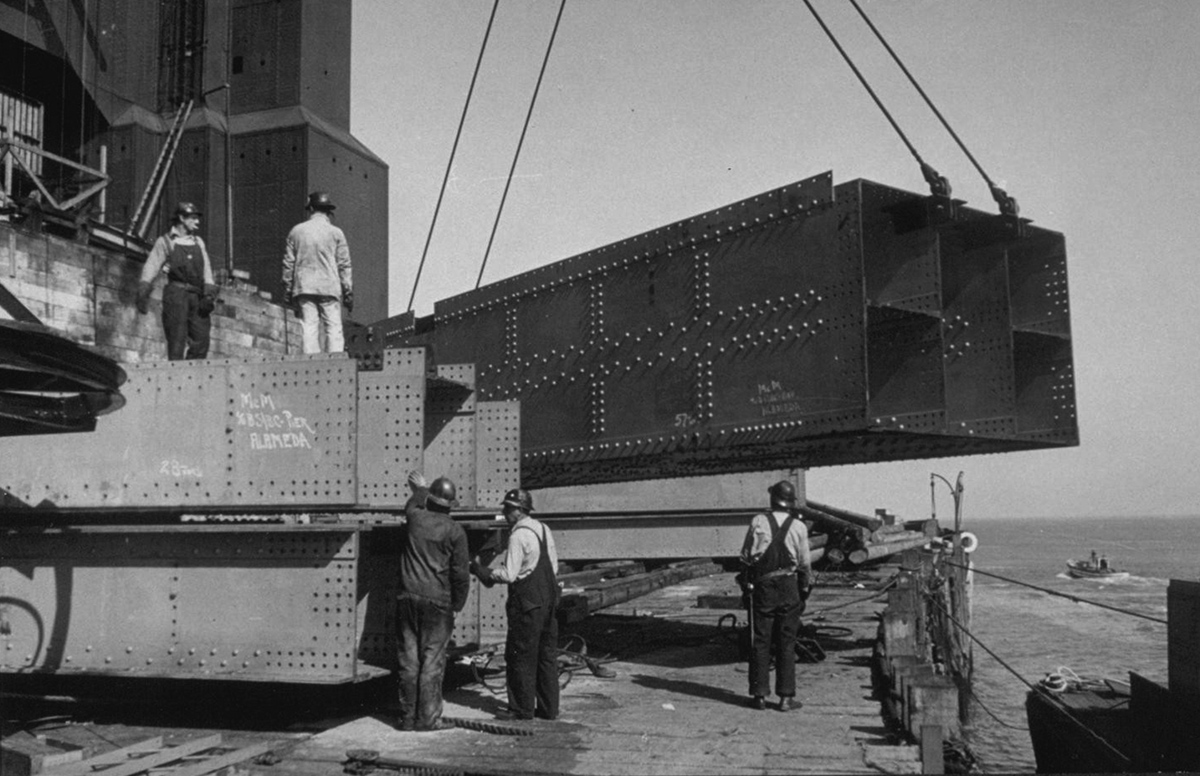 men work on the not-finished bridge in a black and white image