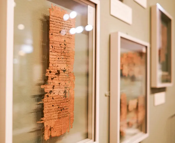 Framed papyri hang on the wall
