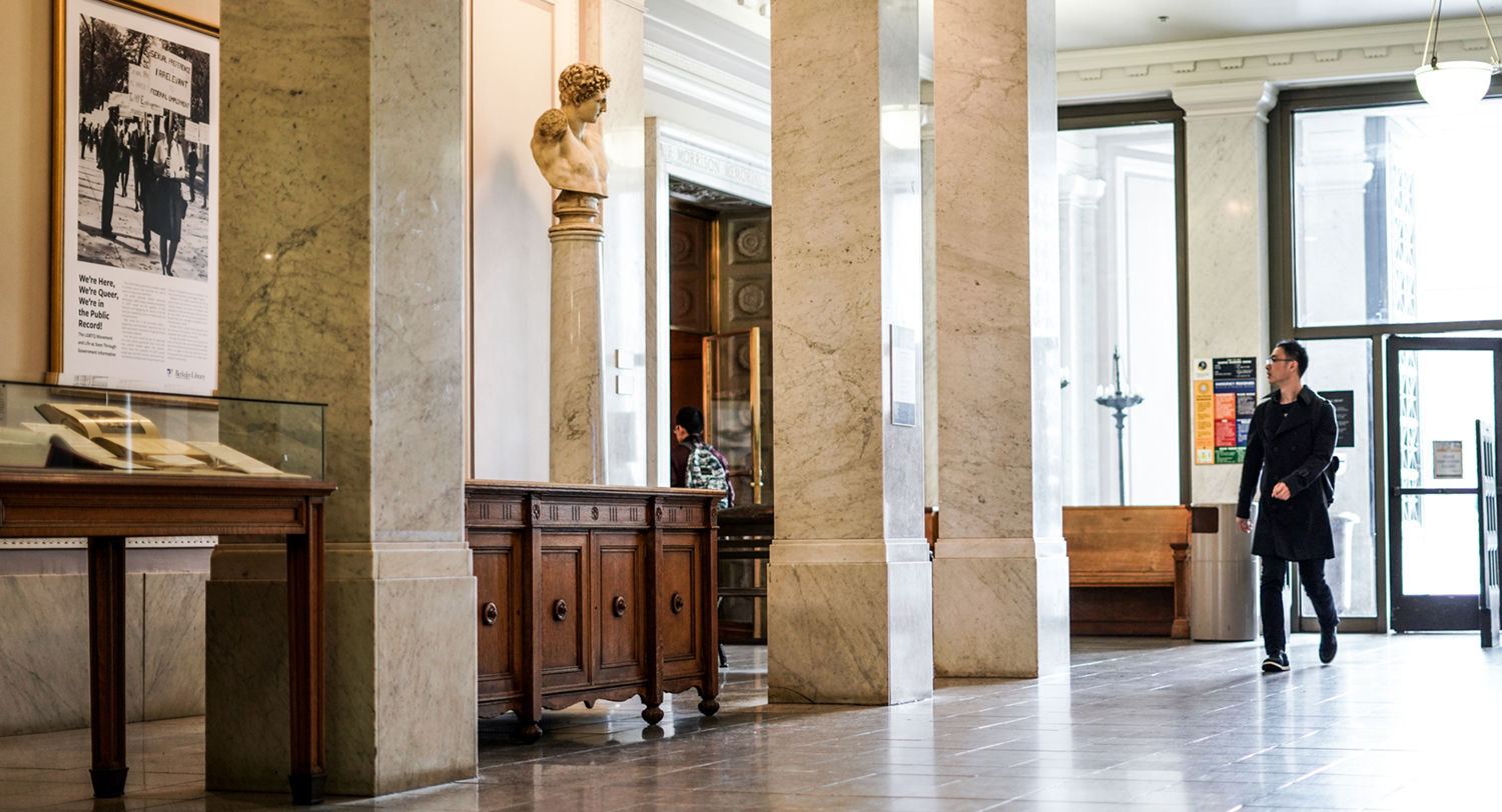 A visitor walks toward the Brown Gallery in Doe Library