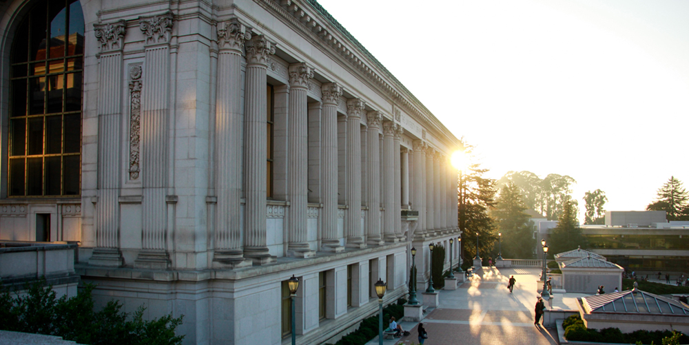 The sun gleams behind Doe Library.
