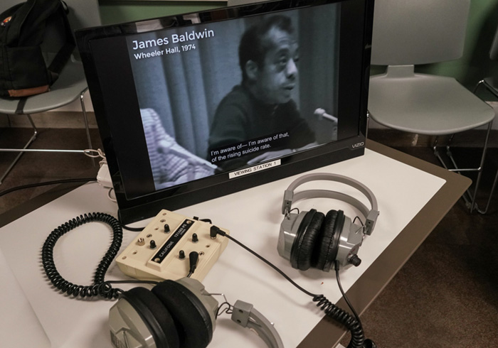 a listening station with tv and headphones sits on a desk