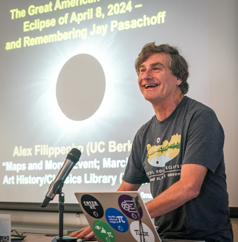 professor smiles as he talks to a group