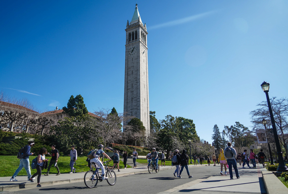 Sather Tower on campus with pedestrians and cyclists below