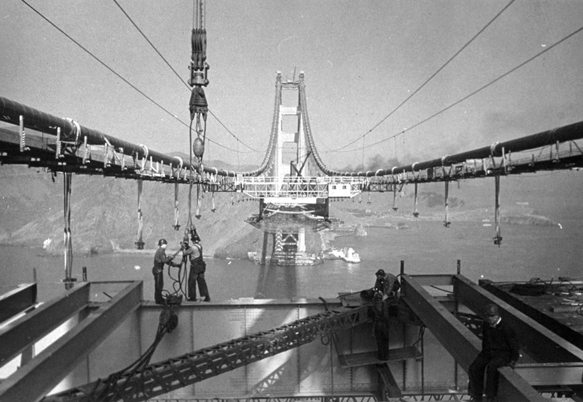 men work on the not-finished bridge in a black and white image