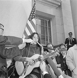 Photo of Joan Baez singing &quot;We Shall Overcome&quot; on Sproul Hall steps before demonstrators file in for sit-in. December 2, 1964