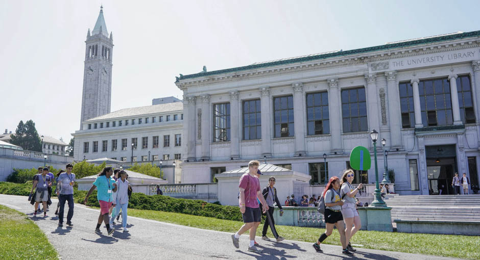 Students on tour walk in front of Doe Library