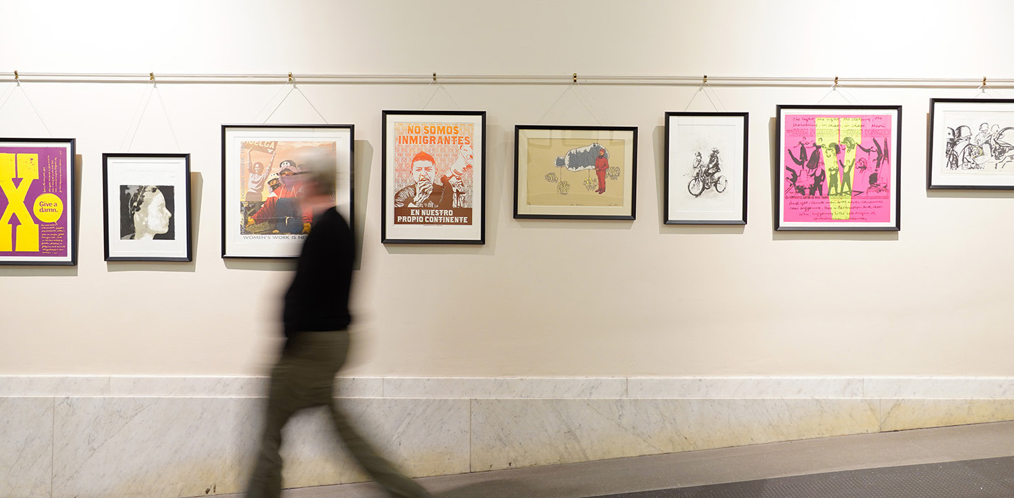 Visitor walks by art on wall