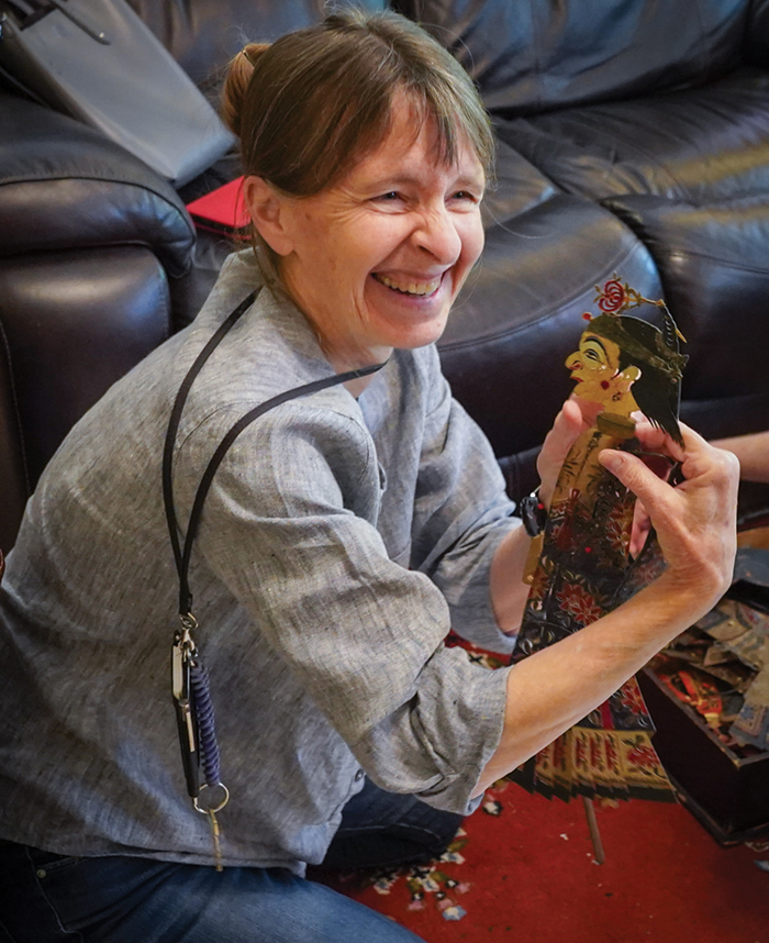 A staff member smiles looking at a puppet
