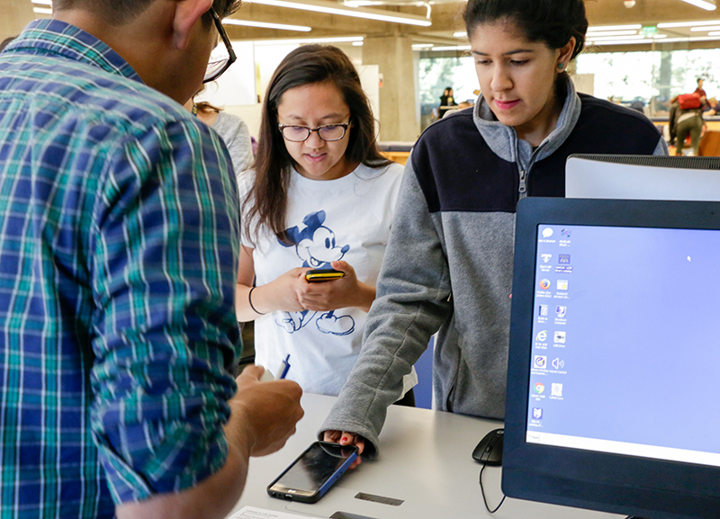 Cheyenne Canizares, left, and Isabella Blanco turn in their smartphones during the Blackout Challenge at Moffitt Library on Dec. 4, 2017. (Photo by Jami Smith for the University Library)