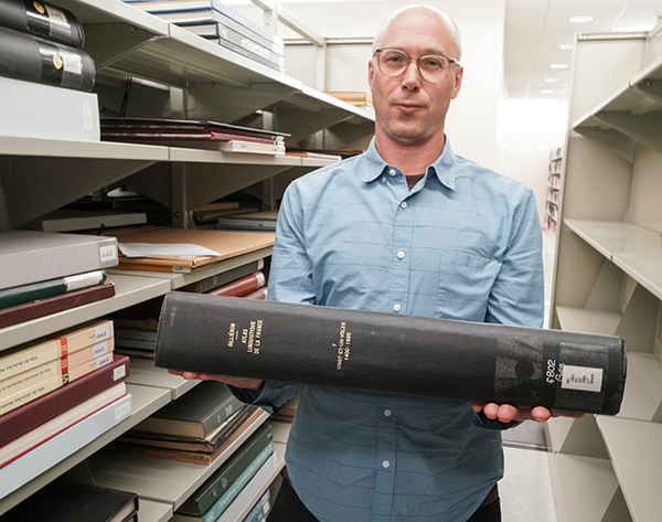 Claude Potts holds big book