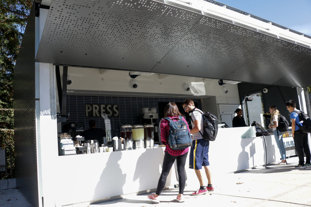 Students order juice and coffee drinks at the opening of the new Press cafe outside the fourth floor of Moffitt Library on Oct. 2, 2017. (Photo by Jami Smith for the University Library)