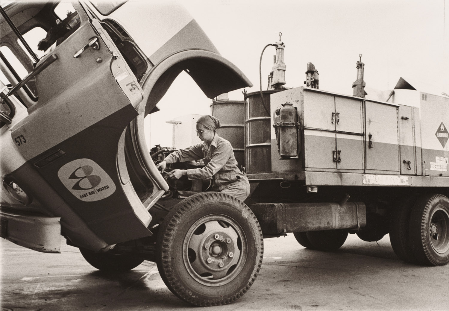 Woman working on a truck engine