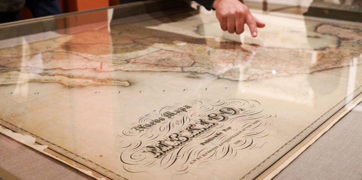 a librarian points to a map on display