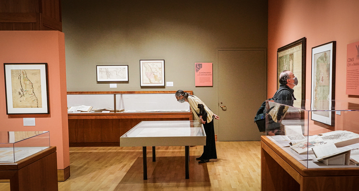 Visitors look at the maps and displays in the Visualizing Place exhibit at the Bancroft Gallery on Sept. 21, 2022. (Photos by Jami Smith for the UC Berkeley Library)