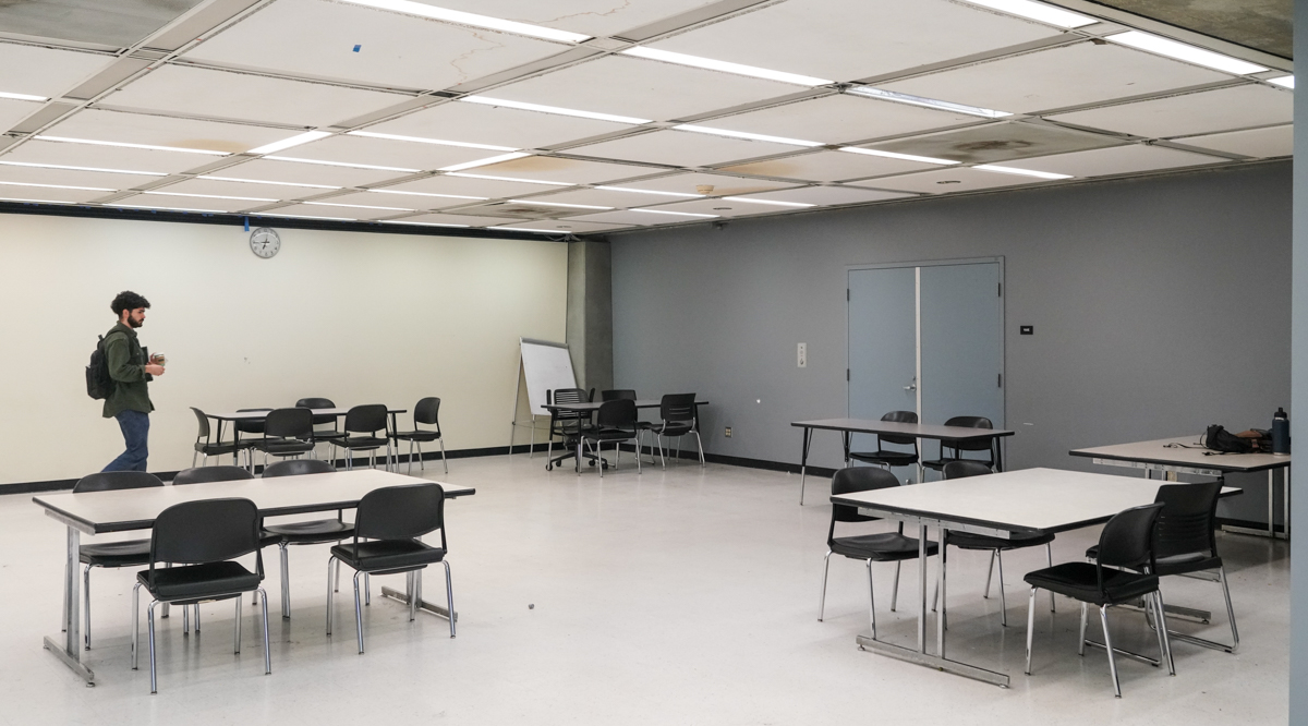 A student looks for a seat in an empty room in Moffitt Library