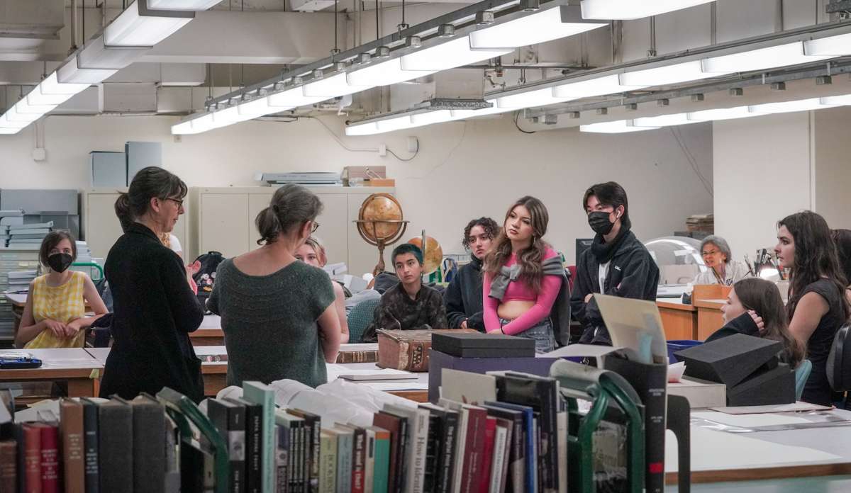 a group of students listen to conservators 