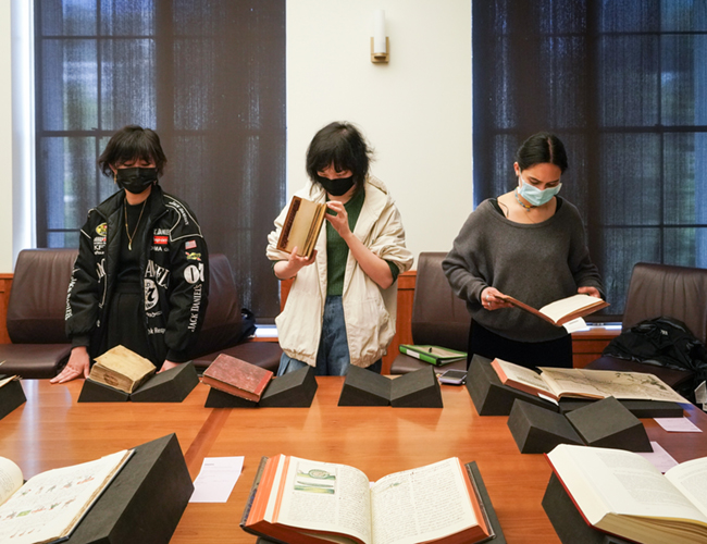 Students look at a table of early books