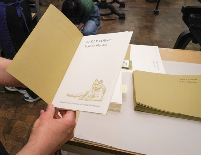 a person holds a pamphlet of poems that the class printed