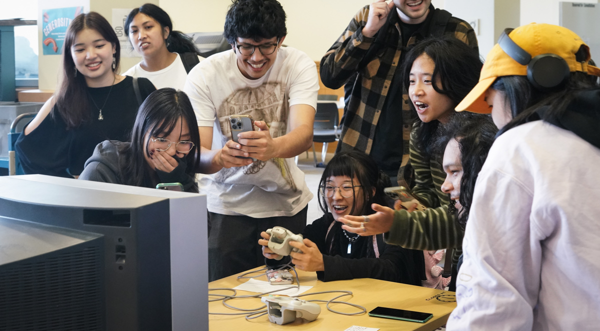Students laugh and point while playing video games
